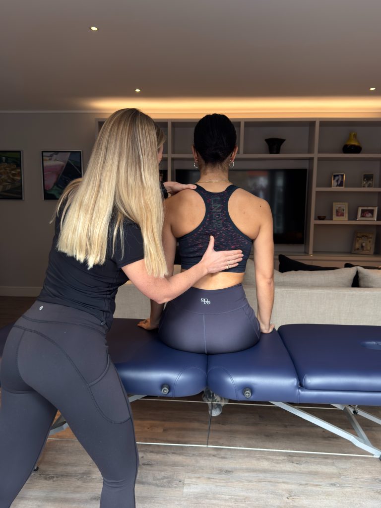 Physiotherapist assessing a patient's upper back and shoulders